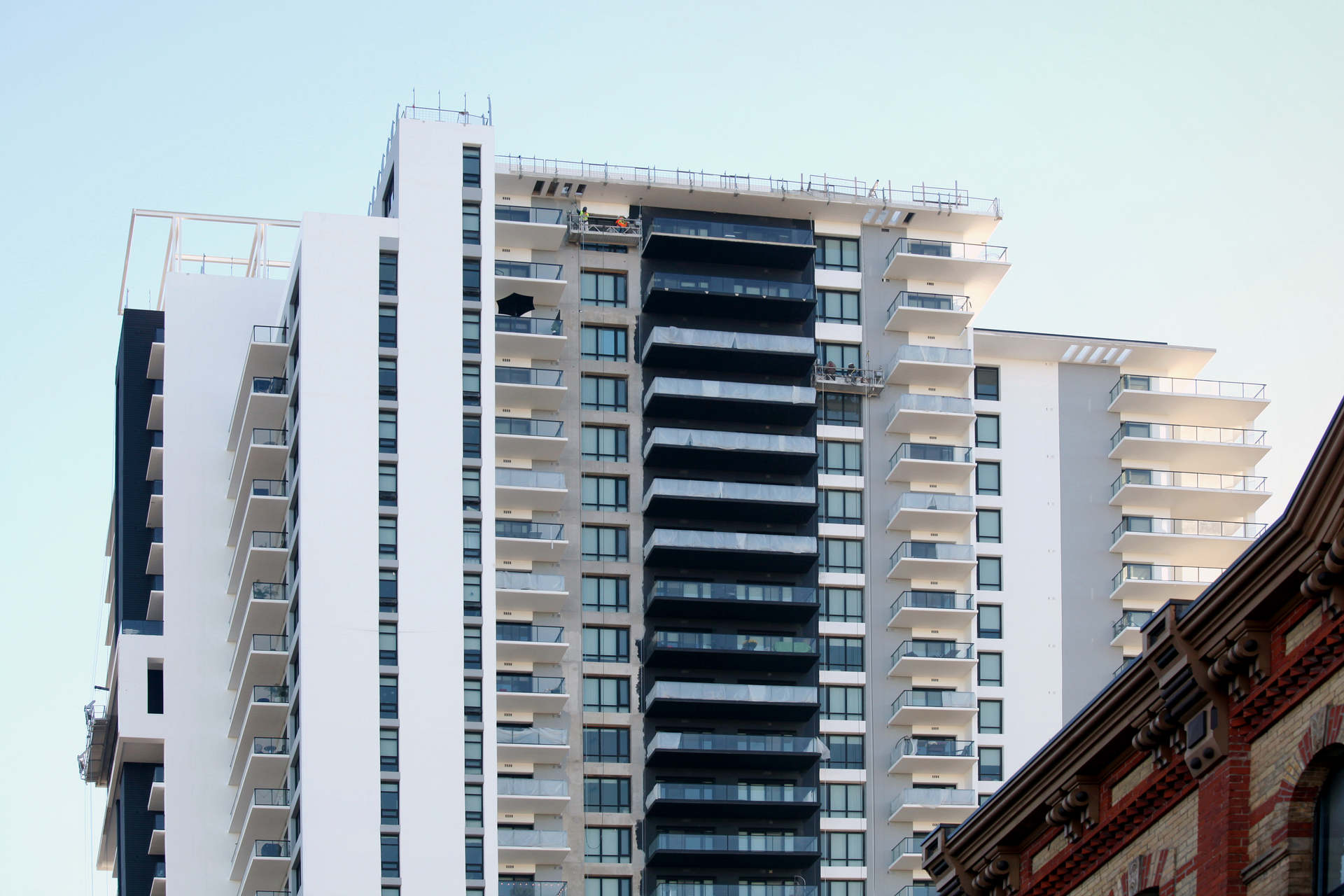 High-Rise apartment building painters and caulkers working on a tall downtown London high rise apartment building. Tall multi-unit residential and/or commercial building in downtown London Ontario. A high-rise exterior painting and caulking project by Performance Painting and Caulking, a London Ontario contractor.